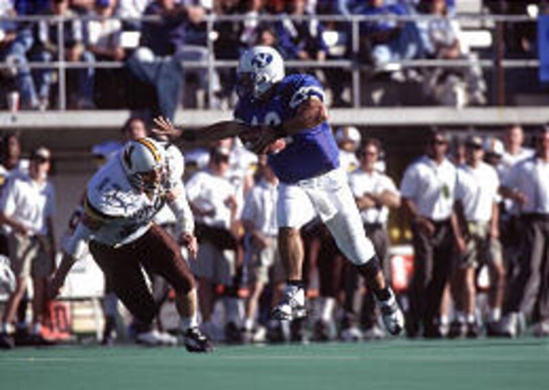 BYU QB Steve Sarkisian, right, is chased by a Wyoming defender during the 1996 WAC title game in Las Vegas.
