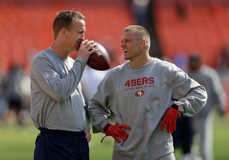 Denver Broncos quarterback Peyton Manning, left, talks with San Francisco 49ers wide receiver Austin Collie, right, before a preseason football game on Thursday, Aug. 8, 2013, in San Francisco.