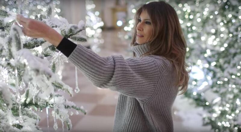 First lady Melania Trump touches a decoration on a Christmas tree in the White House.