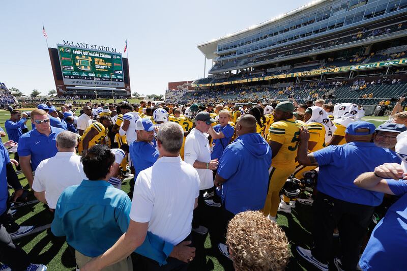 BYU and Baylor players and coaches mingle after the teams knelt to pray together after a game on Sept. 28, 2024.