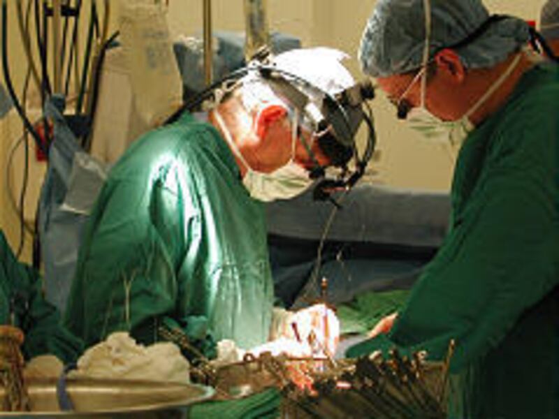 In 2003, Dr. Roger Millar, left, and Dr. Kory Woodbury perform DRMC's first open-heart surgery.