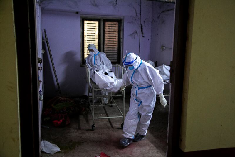Paramedics get ready to load dead bodies of COVID-19 victims onto an ambulance for cremation at a government run hospital in Kathmandu, Nepal, Wednesday.