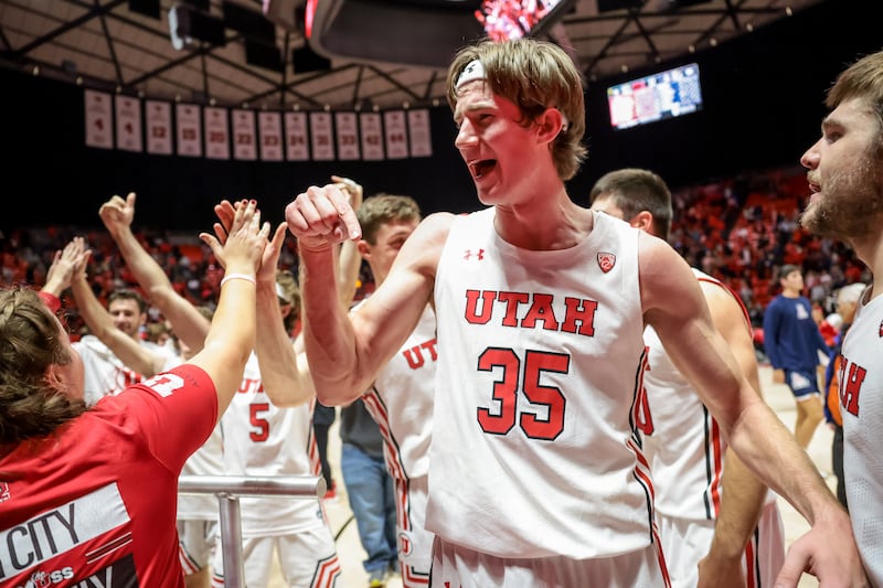 Utah Utes center Branden Carlson (wearing white) celebrates