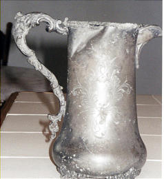 Late-Victorian silver-plated pitcher has had a rough life and has little monetary value despite age.