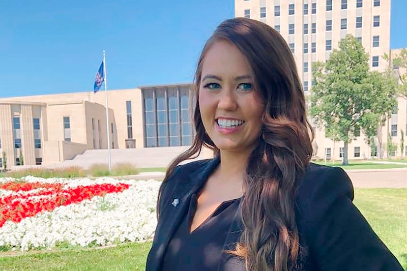 Cara Mund poses for a photo in front of the state Capitol in Bismarck, N.D.