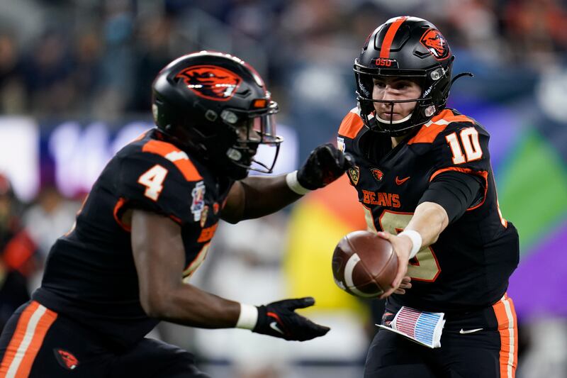 Oregon State quarterback Chance Nolan hands off the ball to running back B.J. Baylor during the LA Bowl against Utah State.