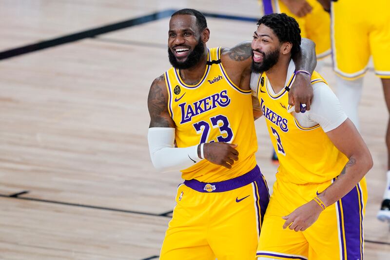 Los Angeles Lakers’ LeBron James (23) and Anthony Davis (3) celebrate after defeating the Denver Nuggets 124-121 during an NBA basketball game Monday, Aug. 10, 2020, in Lake Buena Vista, Fla.