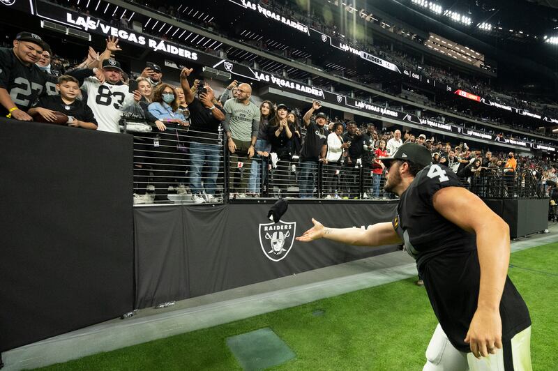 Las Vegas Raiders quarterback Derek Carr (4) tosses a souvenir to a fan after playing the Kansas City Chiefs in Las Vegas.