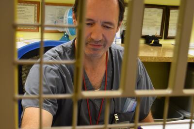 Steven Horsley, a licensed practical nurse, passes a dose of liquid methadone through a barred window where patients line up every morning to take their medication at Metamorphosis in Murray on Tuesday, Nov. 28, 2017.
