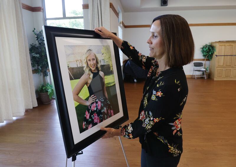 Kara Shaw takes down a photograph of daughter Kathrynn to bring back home at a Utah Department of Public Safety event in Mapleton on Wednesday. Kathrynn Shaw was days away from graduating high school when police say an impaired driver ran through a stop sign and struck the car she was traveling in, resulting in her death. Law enforcement is working extra shifts now through Sept. 6, actively patrolling for impaired drivers.