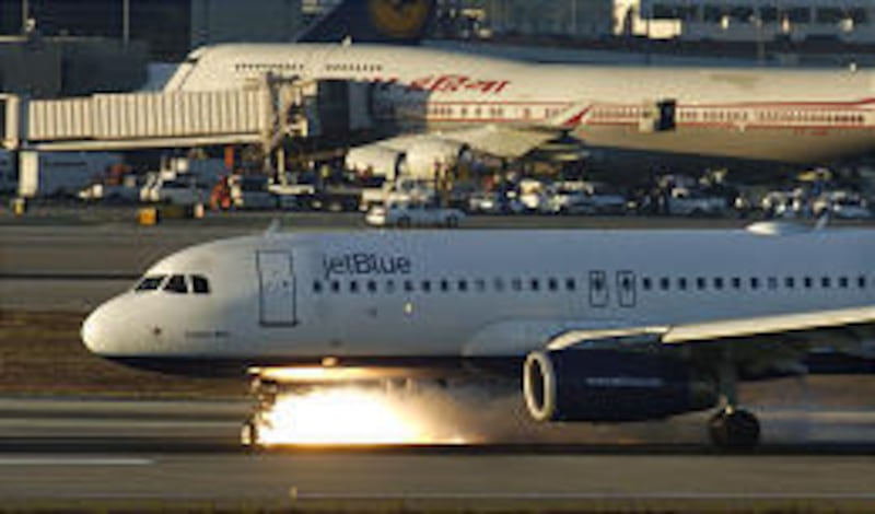 The disabled nose gear of a JetBlue Airbus 320 begins to smoke and burn as the plane makes an emergency landing at Los Angeles International Airport Wednesday.