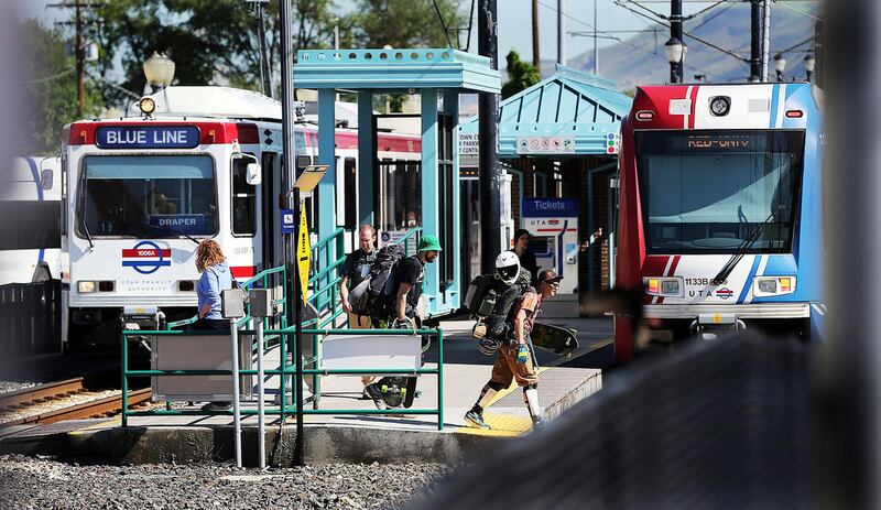 FILE - People get off TRAX trains at 2100 South in Salt Lake City, Monday, May 9, 2016. The Utah Transit Authority is warning TRAX riders to expect delays on both the Red and Blue lines Sunday, Oct. 30, as crews remove two unused sections of track at 4100