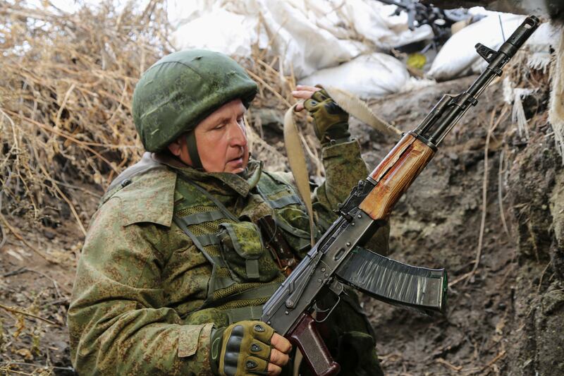 A serviceman holds his Kalashnikov gun as he guards at the line of separation near the Sentianivka, Luhansk region, controlled by Russia-backed separatists in eastern Ukraine.