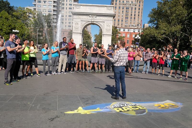 Host Phil Keoghan (center) stands in New York City's Washington Square Park to welcome 11 new teams at the start of the 30th season of "The Amazing Race," which airs on Wednesdays on CBS.