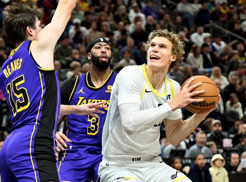 Utah Jazz forward Lauri Markkanen (23) takes the ball at Los Angeles Lakers defenders Austin Reaves (15) and Anthony Davis (3) on Jan. 13, 2024.