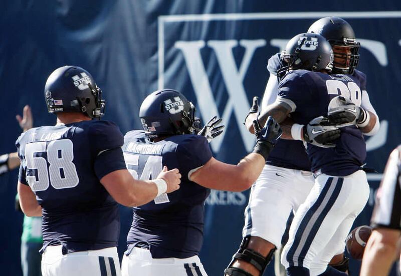 Joey DeMartino (28) of the Utah State Aggies, right, celebrates with teammates after scoring against Hawaii during NCAA football in Logan, Saturday, Nov. 2, 2013.