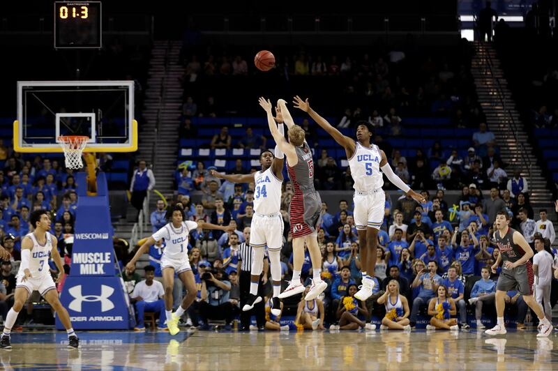 Utah guard Parker Van Dyke (5) makes a winning three-point basket over UCLA guard Chris Smith (5) and guard David Singleton (34) as time expires during the second half of an NCAA college basketball game Saturday, Feb. 9, 2019, in Los Angeles. (AP Photo/Ma