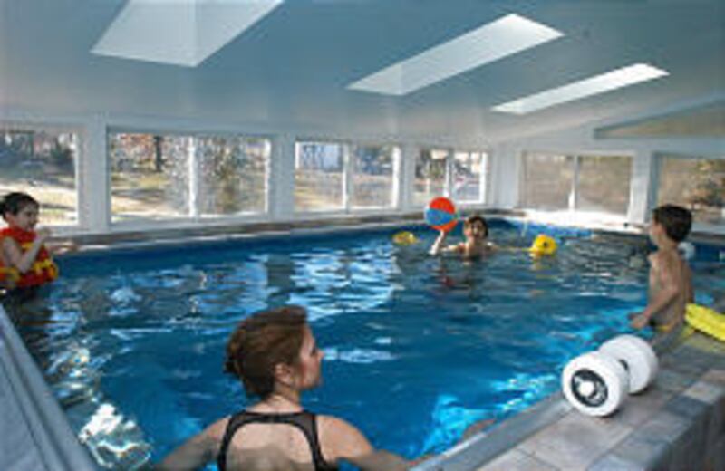 Valarie Arms, rear, swims in her Endless Pool with grandson T.J. Arms, right, and Joanne Boyle and Boyle's son, Vincent, in Landsdowne, Pa.