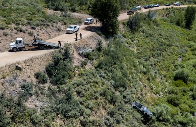 Cars line up down the road as crews work to remove a truck from a ravine after it rolled down the hill in the early hours of the morning in Ogden Canyon near Huntsville on Saturday, July 20, 2019. Two people were killed and four were hospitalized in the w