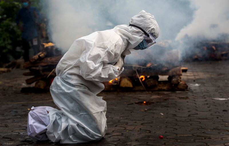 A woman breaks down as she prays before the cremation of a relative who died of COVID-19 in Gauhati, India.