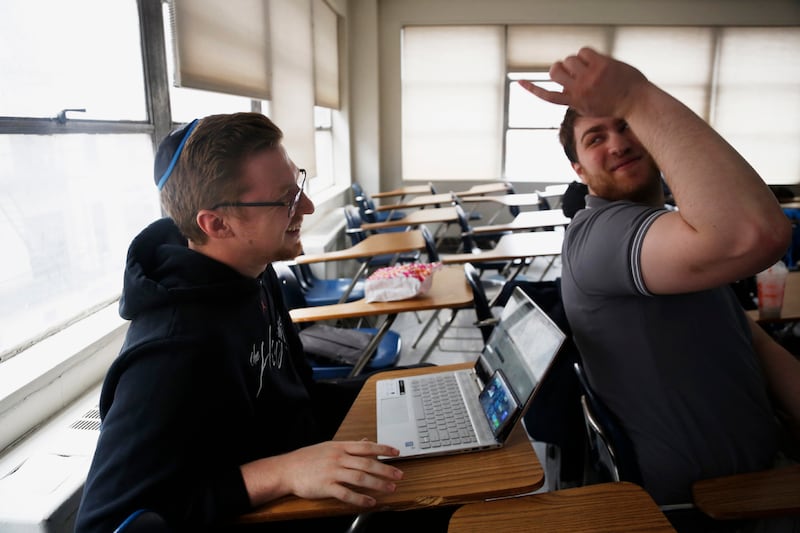 Two members of Yeshiva University’s men’s basketball team, Kevin Bokor and Daniel Katz, attend rabbinical class in New York, Feb. 18, 2020.