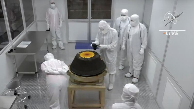 Technicians in a clean room examine the sample return capsule from NASA’s Osiris-Rex mission after it landed at the Department of Defense’s Utah Test and Training Range on Sept. 24, 2023.