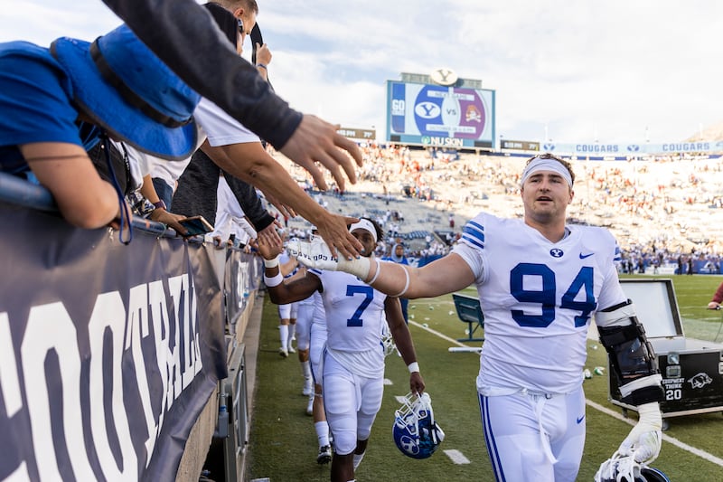 BYU defensive lineman John Nelson high-fives fans in Provo on Saturday, Oct. 15, 2022.