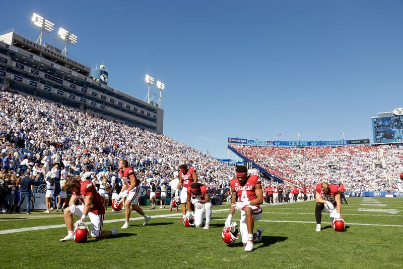 The Arkansas Razorbacks kneel before a game against the BYU Cougars in Provo on Saturday, Oct. 15, 2022.