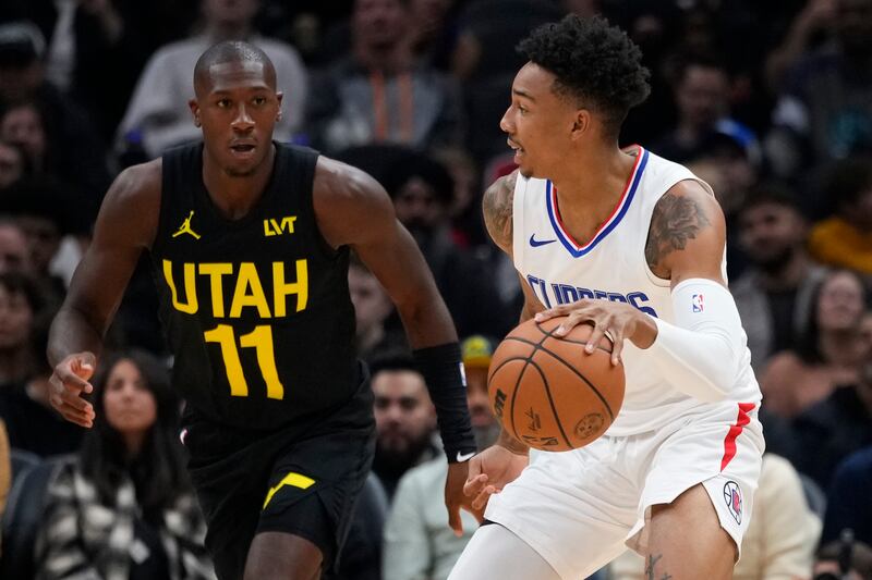 Los Angeles Clippers guard Jordan Miller, right, moves the ball against Utah Jazz guard Kris Dunn during preseason game.