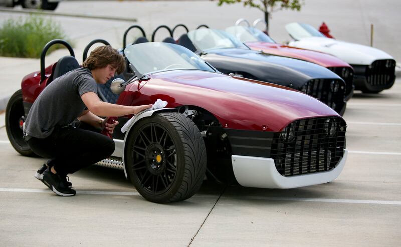 Kai Scholz polishes a Vanderhall Venice autocycle outside Vanderhall Motor Works in Provo on Tuesday, July 17, 2018.