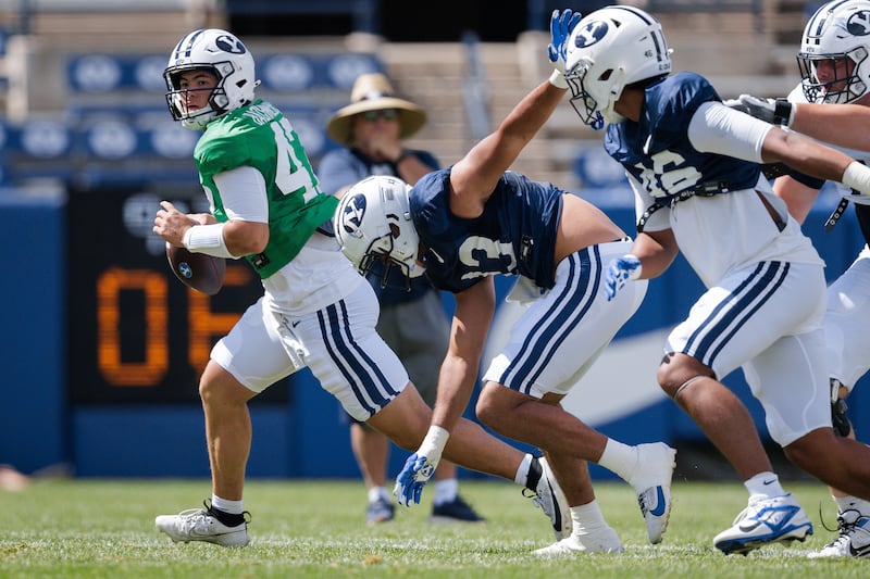 BYU defenders give chase as quarterback Bear Bachmeier scrambles during scrimmage at LaVell Edward Stadium Saturday, Aug. 9, 2025, in Provo.