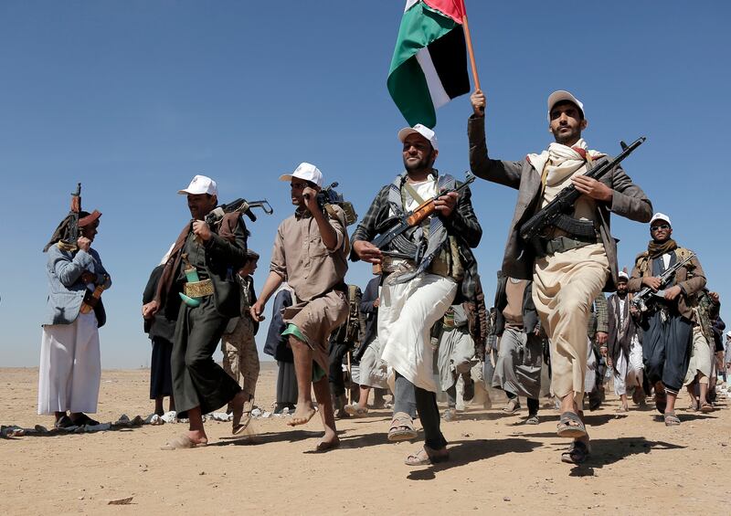 Houthi fighters march during a rally.