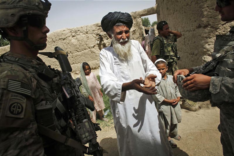 In this picture taken Tuesday, July 6, 2010, Afghan village mullah Bas Mohammad, center, speaks with United States soldier Lt. Ross Weinshanker from Bravo Company, 2nd Battalion of the 508 Parachute Infantry Regiment of the 82nd Airborne, and an interpret