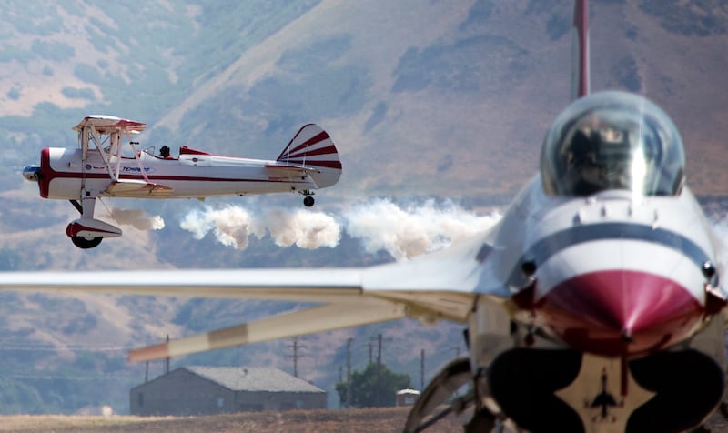 Gary Rower flies a 1941 Stearman past a Thunderbird F-16 during the Warriors Over the Wasatch Air and Space Show at Hill Air Force Base on Saturday, June 23, 2018.