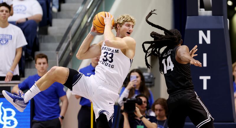 Brigham Young Cougars forward Caleb Lohner , wearing white, grabs a rebound away from Long Beach State 49ers guard Colin Slater