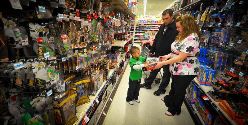 Kevin, center, Jolie, right, and Alex Lewis shop for a family they adopted for Christmas, Thursday Dec 15, 2011 at a Kmart in Omaha, Neb. The Lewises had their layaway paid off at Kmart by an unknown good Samaritan. 'Layaway angels' are anonymously footi