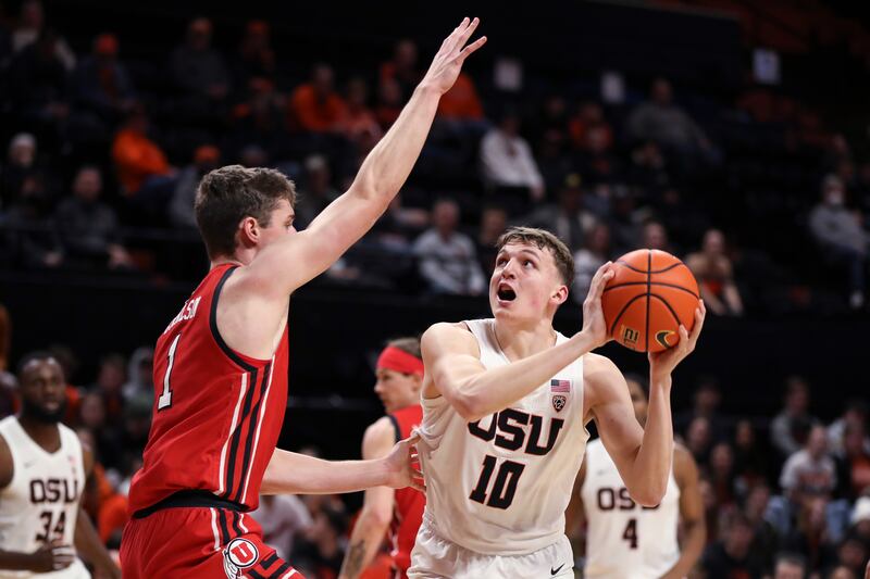 Oregon State forward Tyler Bilodeau (wearing white) looks to the basket as Utah forward Ben Carlson (1) defends