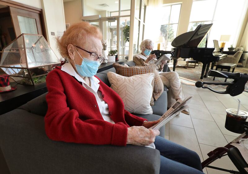 Residents of The Ridge Foothill, read newspapers while socially distanced at the assisted living community in Salt Lake City.