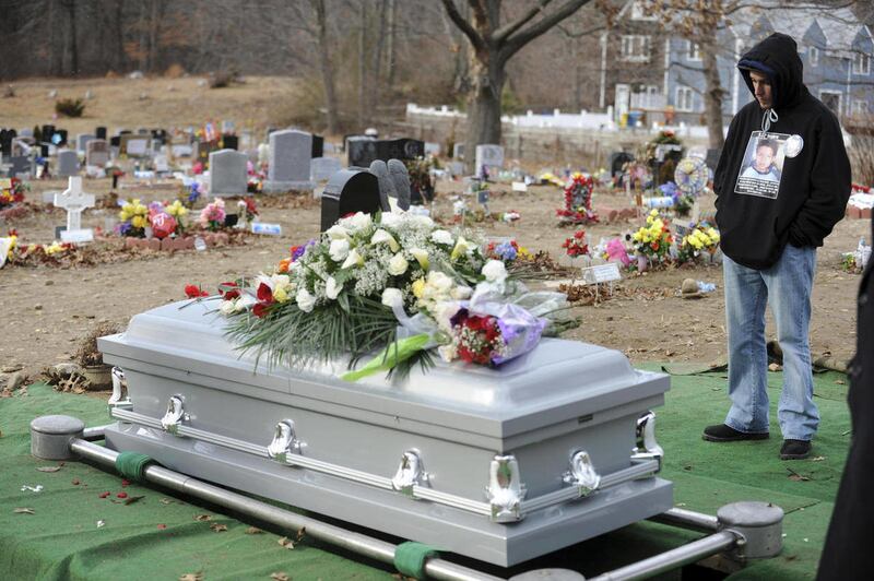 AP MEMBER FEATURE EXCHANGE ADVANCE FOR JUNE 10 - In this Jan. 13. 2012 photo, Jeremy Padilla stands over the casket of his 14-year old nephew, Justin Thompson, at Park Cemetery in Bridgeport, Conn. Padilla was the last mourner to leave the burial site fo