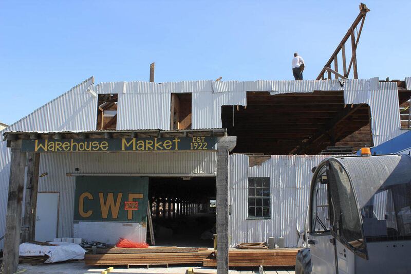 In this Aug. 11, 2012, photo, workers "deconstruct" a building that once was a warehouse for Columbia Wards Fisheries in Kenai, Alaska. Construction materials from the building will be used in other local facilities.
