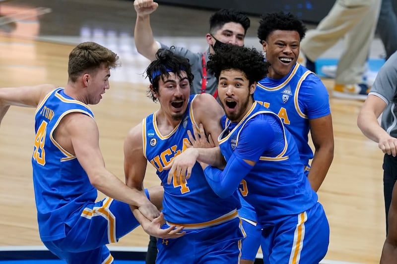 UCLA players celebrate after an Elite 8 game against Michigan at Lucas Oil Stadium, March 31, 2021, in Indianapolis.