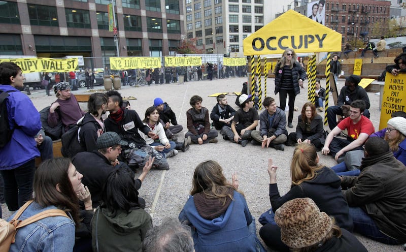 FILE - In this Nov. 15, 2011 photo, Occupy Wall Street protesters hold a general assembly meeting inside an enclosed site near Canal Street in New York hours after police made an early-morning raid of the park that had become the epicenter of the OWS move
