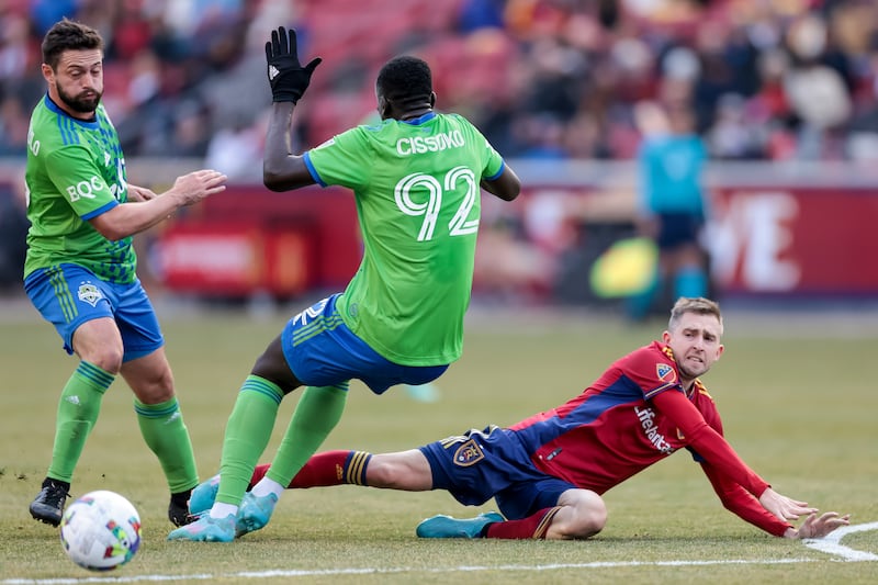 Real Salt Lake midfielder Andrew Brody hits the turf after passing by Seattle Sounders FC midfielder Joao Paulo and defender Abdoulaye Cissoko during the game at Rio Tinto Stadium in Sandy on Saturday, March 5, 2022.