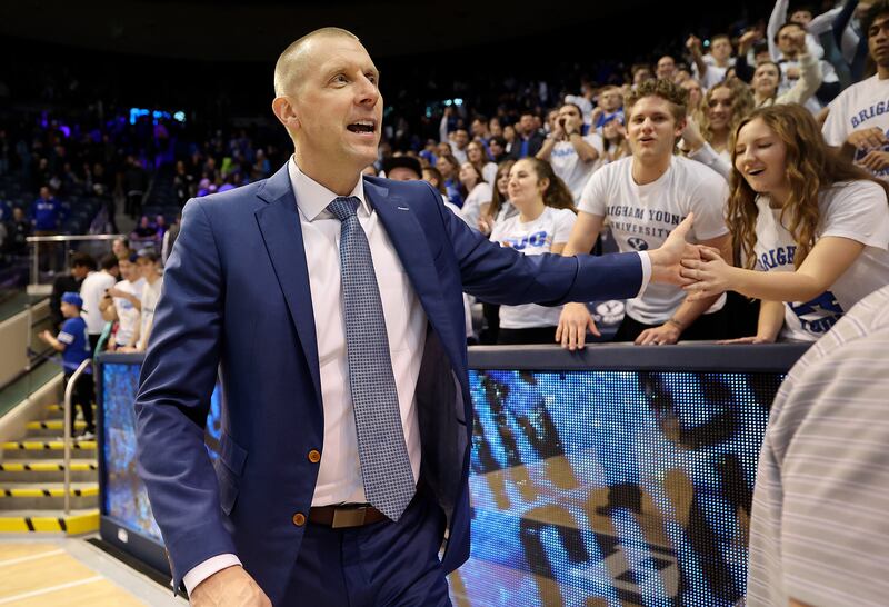 BYU men’s head basketball coach Mark Pope high-fives fans in the front row of the student section after BYU beat Bellarmine.