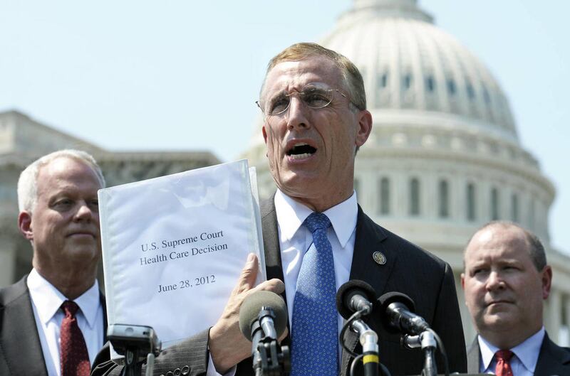 FILE - In this Thursday, June 28, 2012 file photo, Rep. Tim Murphy, R-Pa., center, holds up a copy of the Supreme Court's health care ruling during a news conference by the GOP Doctors Caucus on Capitol Hill in Washington. Medicaid advocates are on pins a