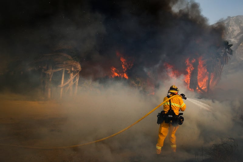 A firefighter battles a wildfire at Faria State Beach in Ventura, Calif., Thursday, Dec. 7, 2017. The wind-swept blazes have forced tens of thousands of evacuations and destroyed dozens of homes.