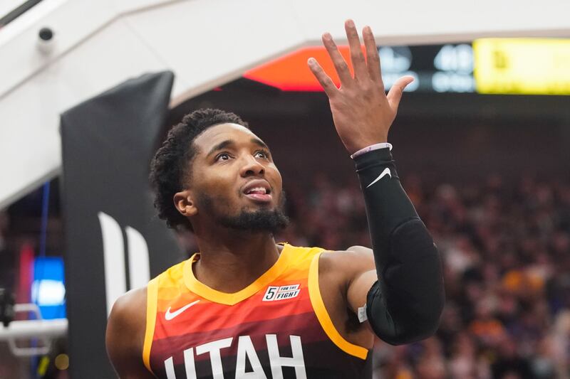 Utah Jazz guard Donovan Mitchell reacts after being fouled by Golden State Warriors defenders during an NBA game at Vivint Arena in Salt Lake City.