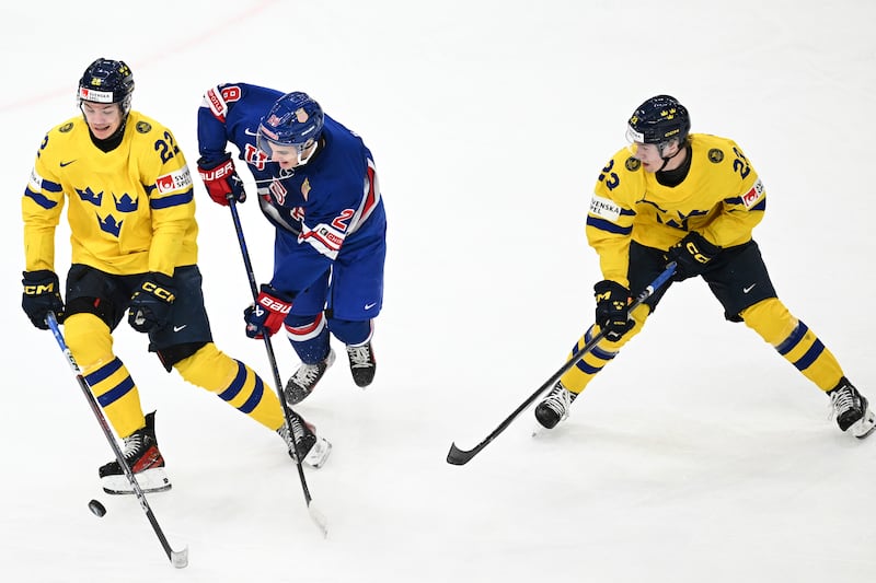 Sweden's Anton Wahlberg and Jonathan Lekkerimaki in action with USA's Sam Rinzel during the IIHF World Junior Championship ice hockey final match between Sweden and USA at Scandinavium in Gothenburg, Sweden, Friday Jan. 5, 2024.