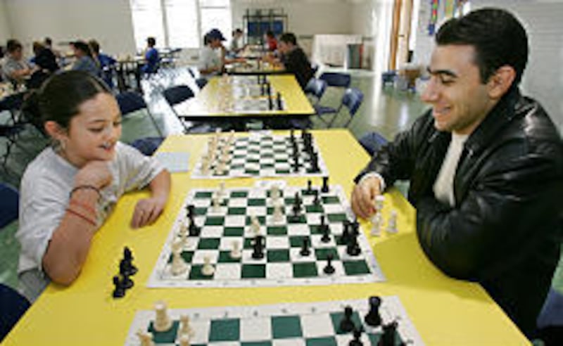 World open champion Varuzhan Akobian plays chess on Saturday with Sia Skipps at the McGillis School.