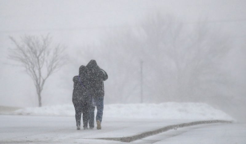A couple walk on the Kansas State University campus during blizzard conditions in Manhattan, Kan., Saturday, Feb. 23, 2019.